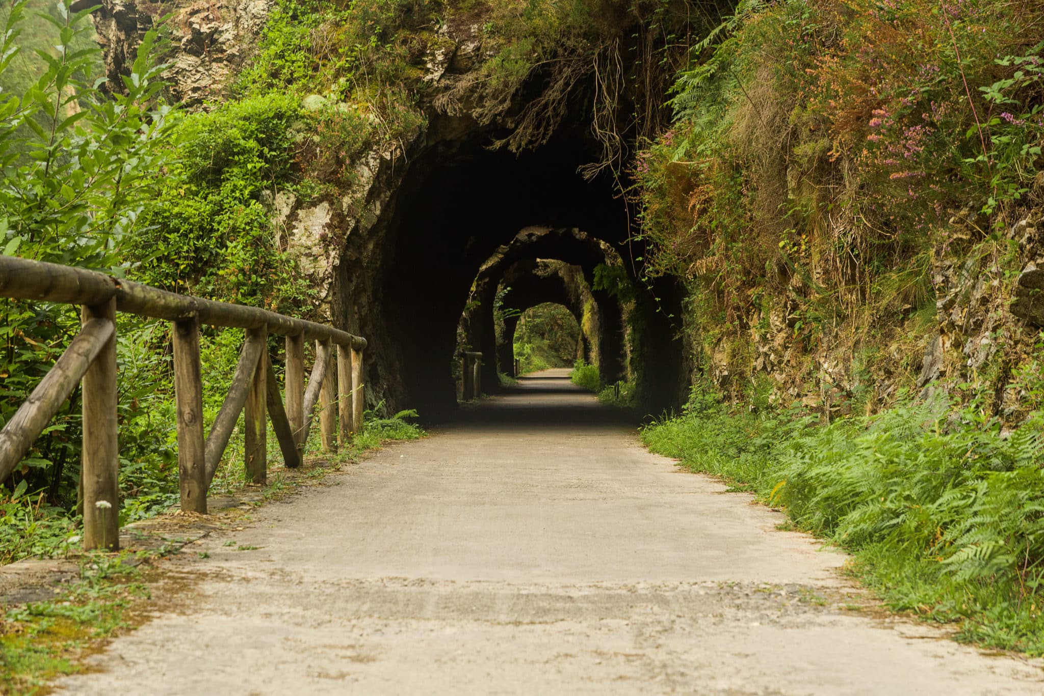 Ciclistas atravesando un túnel de roca
